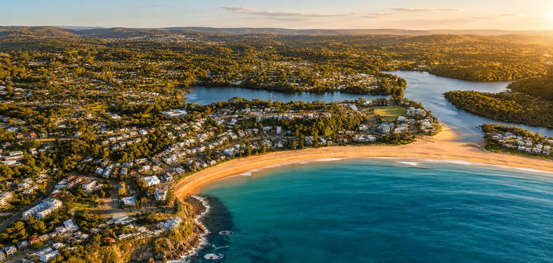 Aerial sunset view over Avoca Beach, Avoca Lake and surrounding homes