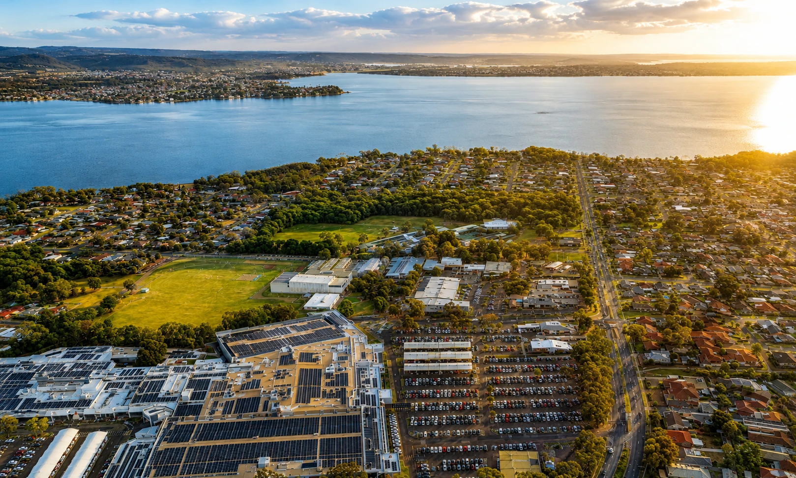 Aerial sunset view over Lake Haven Centre, surrounding homes and the waterfront