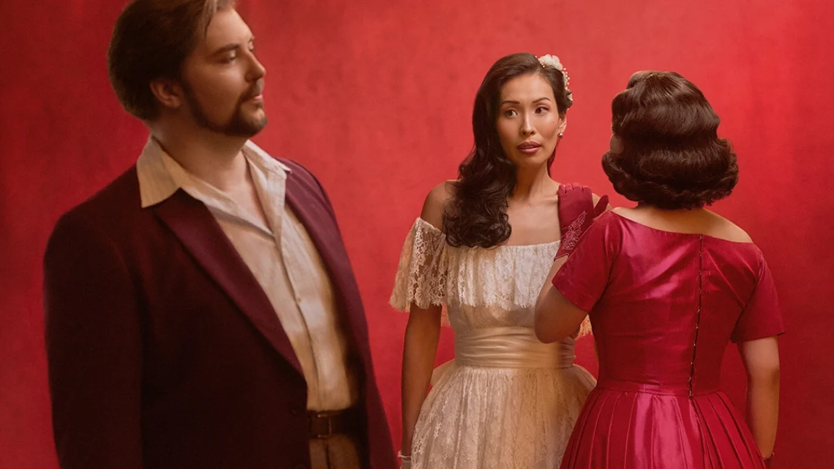 Don Giovanni opera cast in costume against a red theatrical backdrop