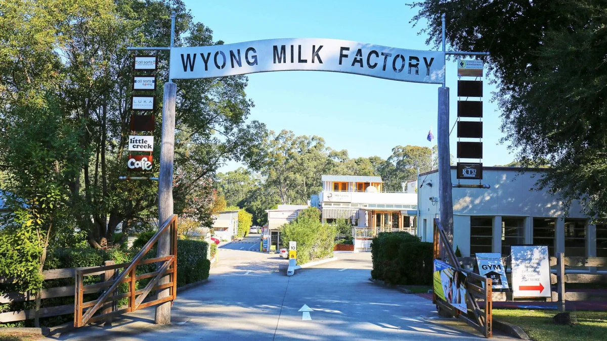 Wyong Milk Factory entrance arch and the businesses inside the leafy heritage precinct